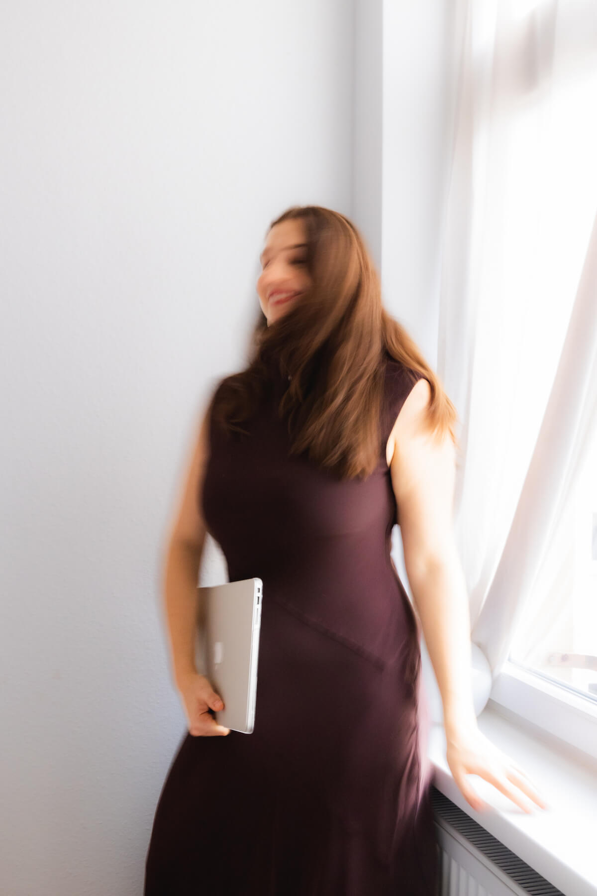 verschwommenes Bild von Alisa Fries mit Laptop in der Hand