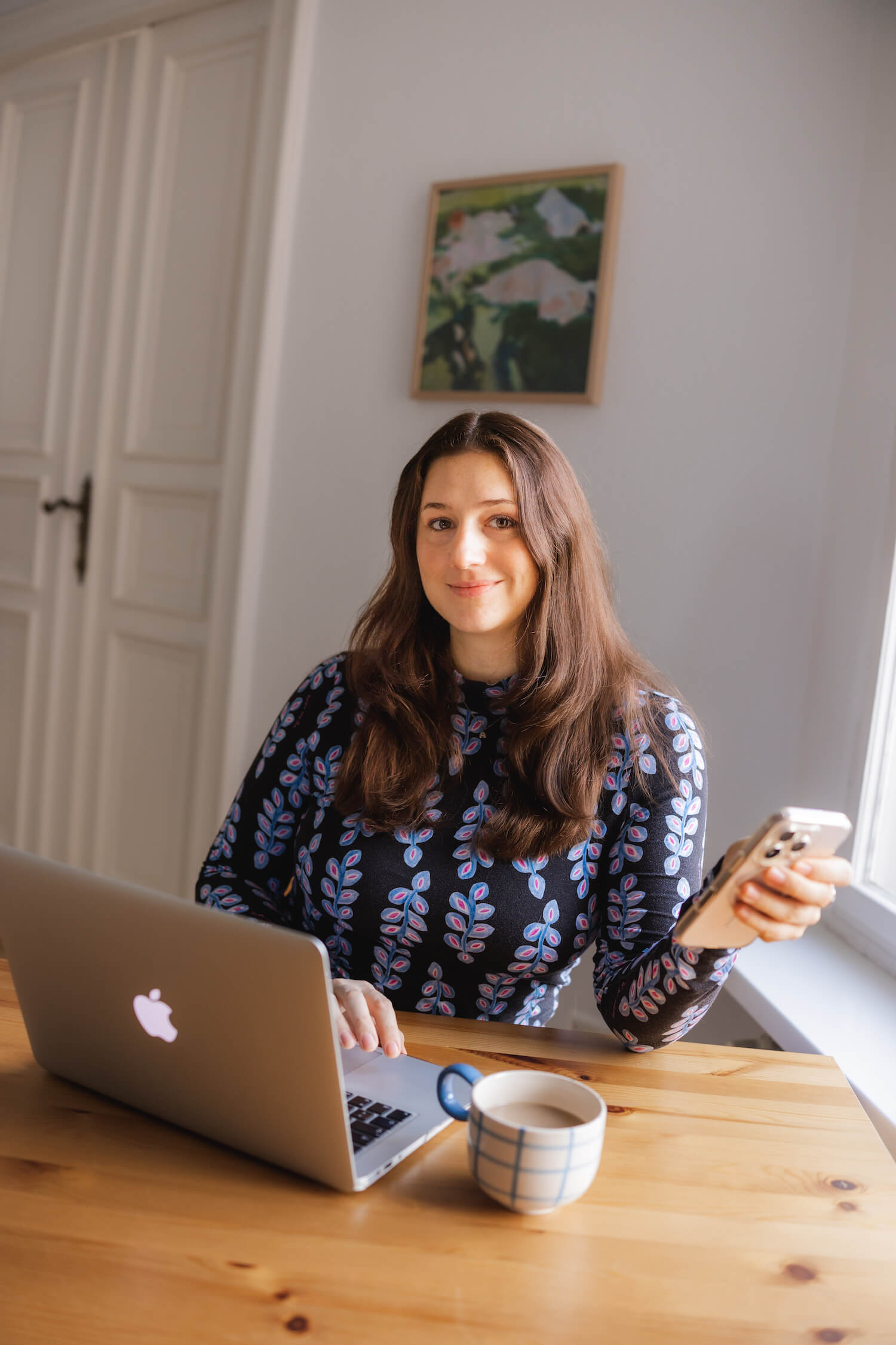 Alisa Fries sitzt am Schreibtisch mit Handy in der Hand