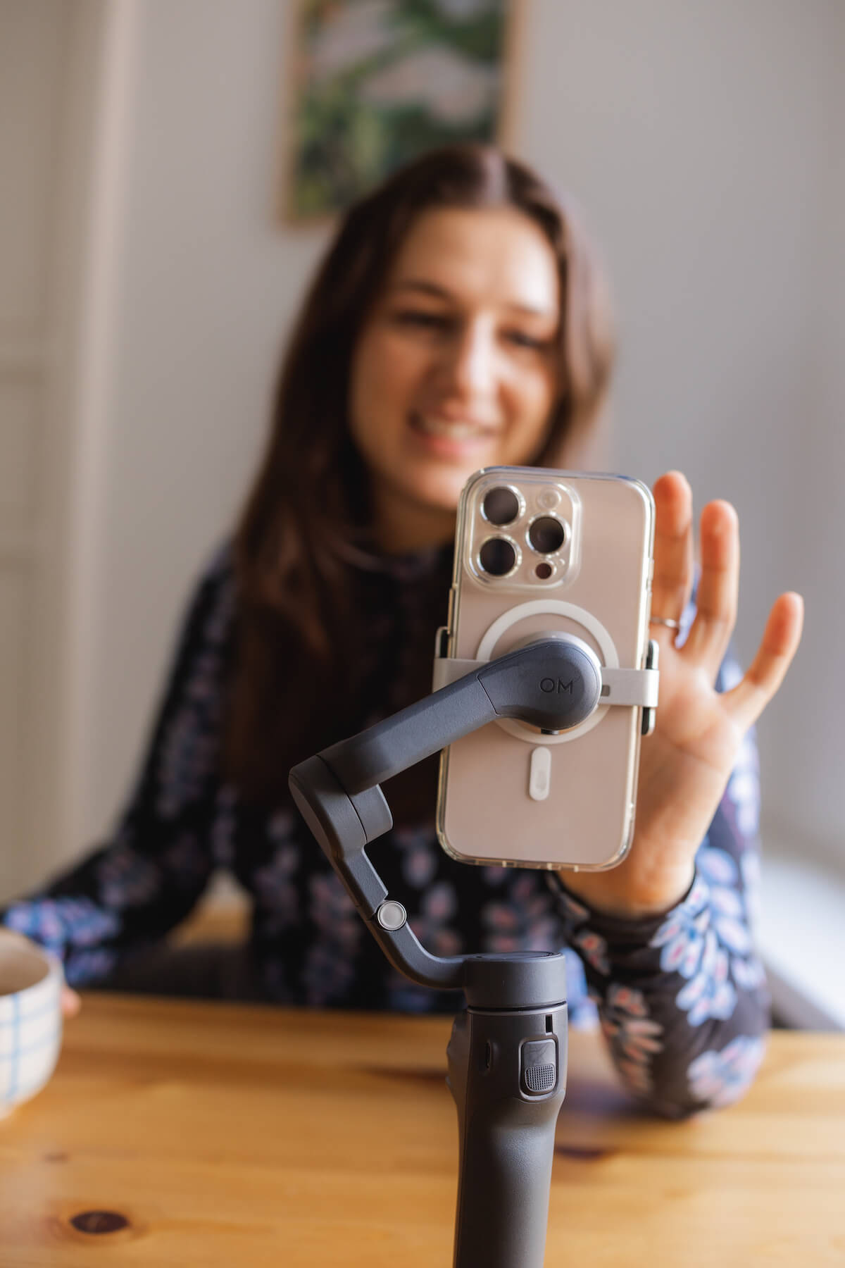 Alisa Fries im Hintergrund tippt vorn auf ein Handy auf einem Stativ