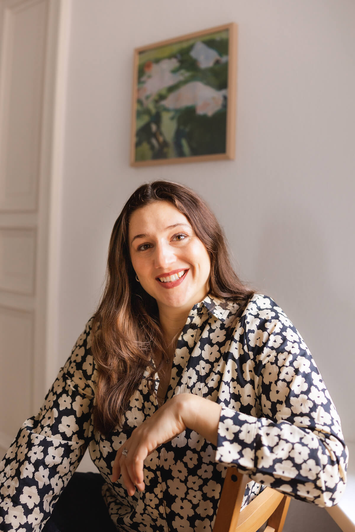 Alisa Fries sitzt seitlich auf einem Stuhl, lächelt in die Kamera