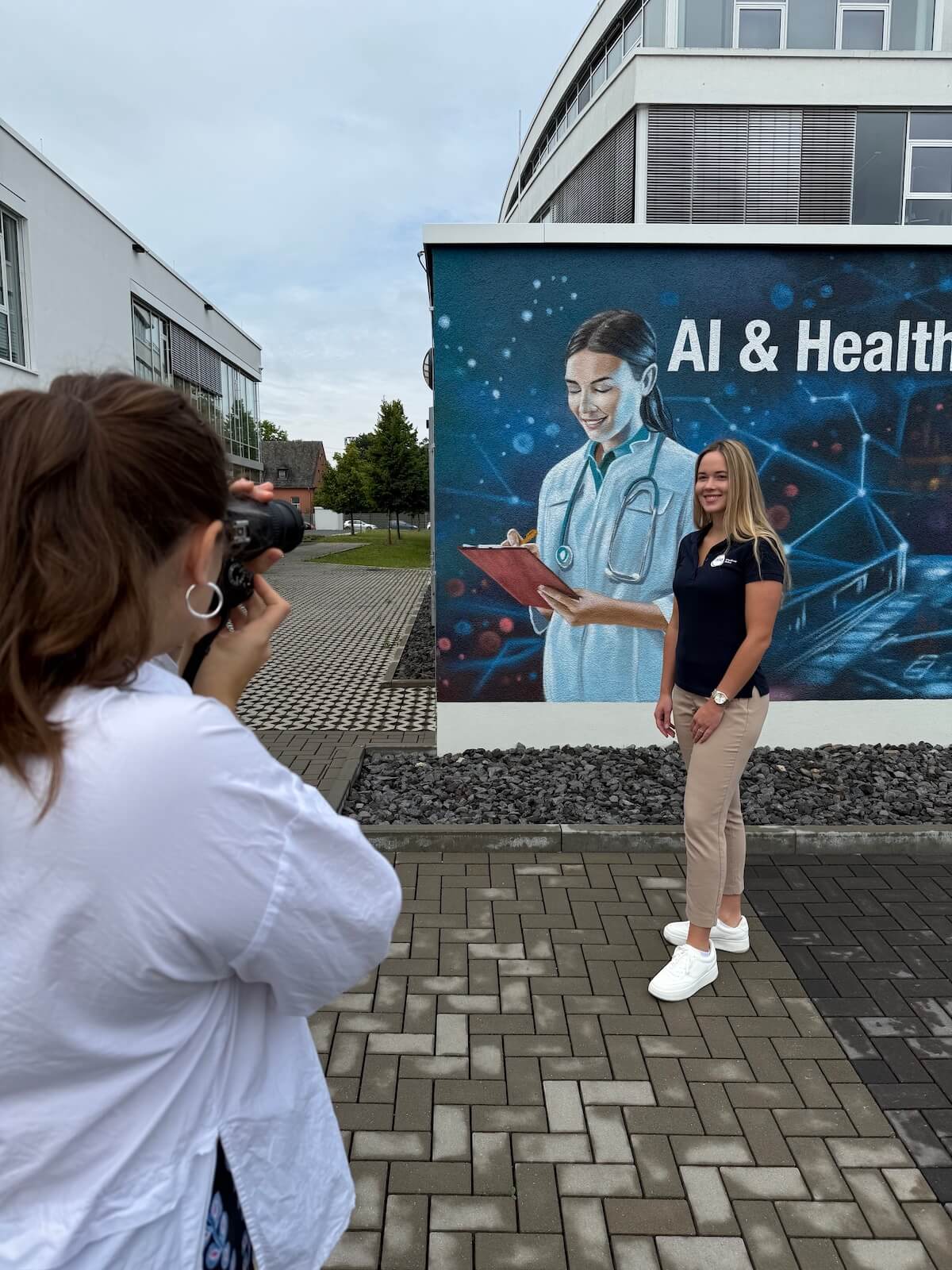 Alisa Fries fotografiert eine blonde Frau vor bunter Hauswand